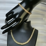 Gold-plated, iced-out tennis chain necklace and matching bracelet.